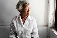 Elderly asian woman looking out of the window