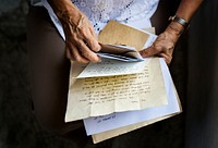 Elderly woman holding old letters in her hands