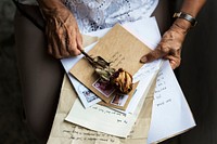 Elderly woman holding old letters and dried rose