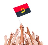 Group of people reaching for and holding the Angolan flag.
