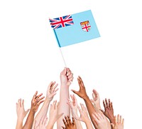 Group of multi-ethnic people reaching for and holding the flag of Fiji.