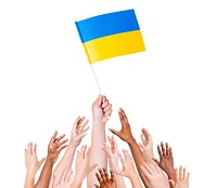 Group of multi-ethnic people reaching for and holding the flag of Ukraine.