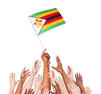 Group of multi-ethnic people reaching for and holding the flag of Zimbabwe.