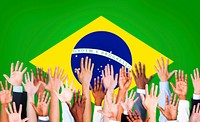 Group of Multi-Ethnic Arms Raised and a Flag of Brazil as a Background