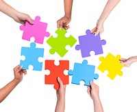 Human hands holding jigsaw puzzle.
