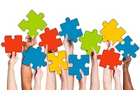 Human Hand Holding Colorful Jigsaw Puzzle Pieces