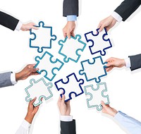 Group Of Business People Holding Pieces Of Puzzle