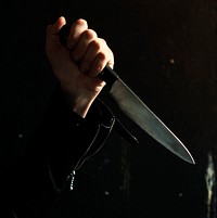 Dark photo of a hand with a knife