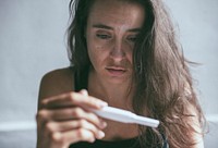 Depressed woman holding a pregnancy test