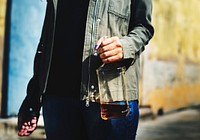 person holding an almost empty bottle of liquor
