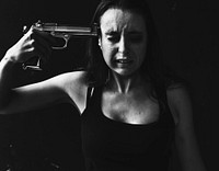 Distraught woman pointing a gun to her head