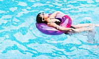 Asian woman floating in the swimming pool with inflatable tube