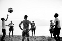 Group of diverse friends playing beach ball together