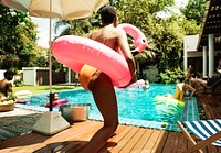 African woman jumping to the pool with inflatable tube