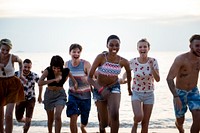 Group of diverse friends running at the beach together