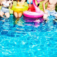 A diverse group of friends enjoying summer time by the pool with inflatable floats