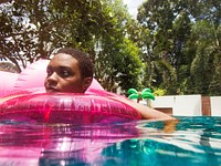 Closeup of african descent woman floating in the pool with inflatable