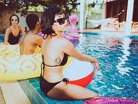 Closeup of asian woman sitting by the pool with diverse friends