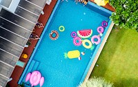 Group of diverse friends enjoying the pool with inflatable tubes