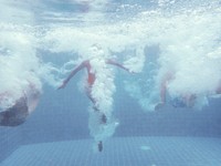 Group of people jumped down to the swimming pool underwater shot