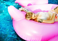 A closeup of a Caucasian woman floating in the pool on an inflatable float
