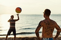 Men friends playing beach ball together