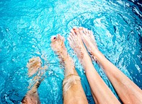 Pair of bare feet in swimming pool