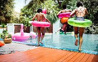 Group of woman friends jumping to the swimming pool