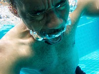 Closeup of senior black man underwater at swimming pool