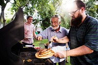 Men helping cooking homemade steak at bakcyard summer party