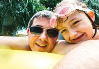 Caucasian father daughter enjoying summer time together in the pool