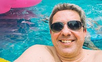 Man with sunglasses floating in a pool