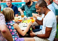 Black man clinking drink with young girl in summer party
