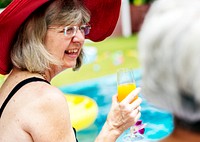 Closeup of senior caucasian woman with juice by the pool