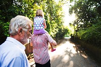 Rear view of caucasian family walking outdoors together