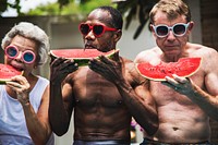 Group of senior friends eating watermelon on the poolside