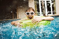 Young caucasian boy enjoying floating in the pool with tube