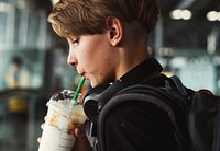 Young caucasian traveler drinking beverage in the airport