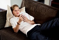 Young caucasian boy using mobile phone on the couch