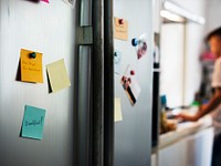 Closeup of notes on fridge doors in kitchen