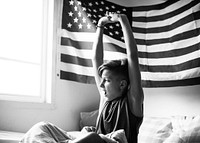 Young caucasian boy waking up stretching arms grayscale