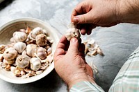 Closeup of hand peeling garlic