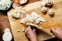 Hands using a knife chopping onion