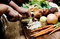 Closeup of hand with knife cutting fresh vegetable