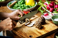 Hands using a knife chopping mushroom