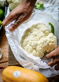 Closeup of hand with cauliflower in plastic bag