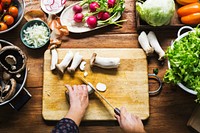 Aerial view of hand with knife cutting mushroom