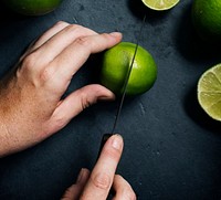 Aerial view of hands with knife cutting lime