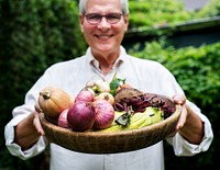 Senior adult man holding a tray with vegetable on it