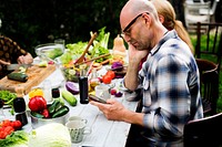 Man using a smart-phone at a food table